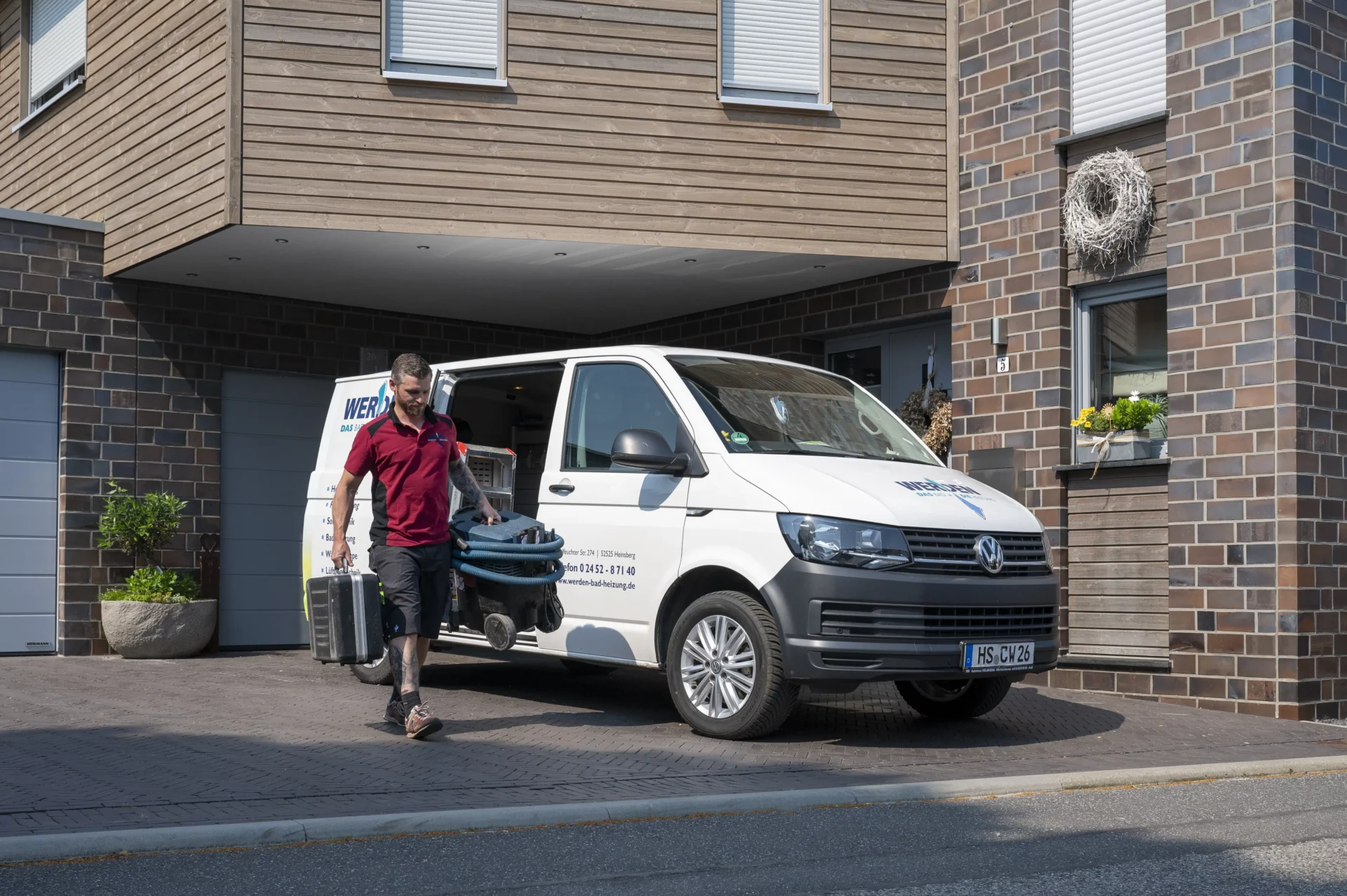 Monteur lädt Material aus Kastenwagen aus